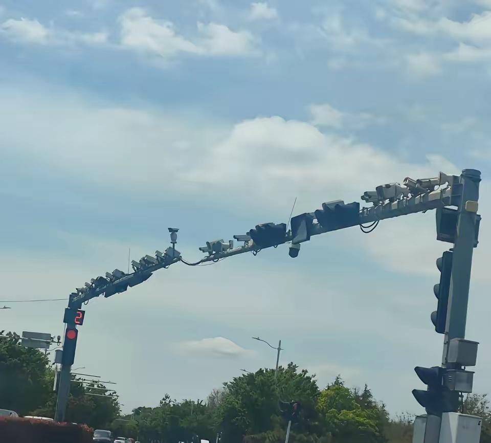 就问你一件事，开车从这儿经过，心里怕不怕？青岛这个路口一根杆子挂了近20个摄