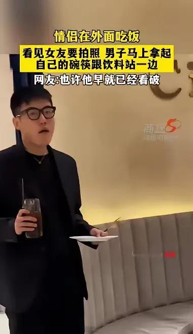 情侣在餐厅吃饭，看到女生拿手机拍照，男人很自觉地退到一旁。他其实早已看清了自