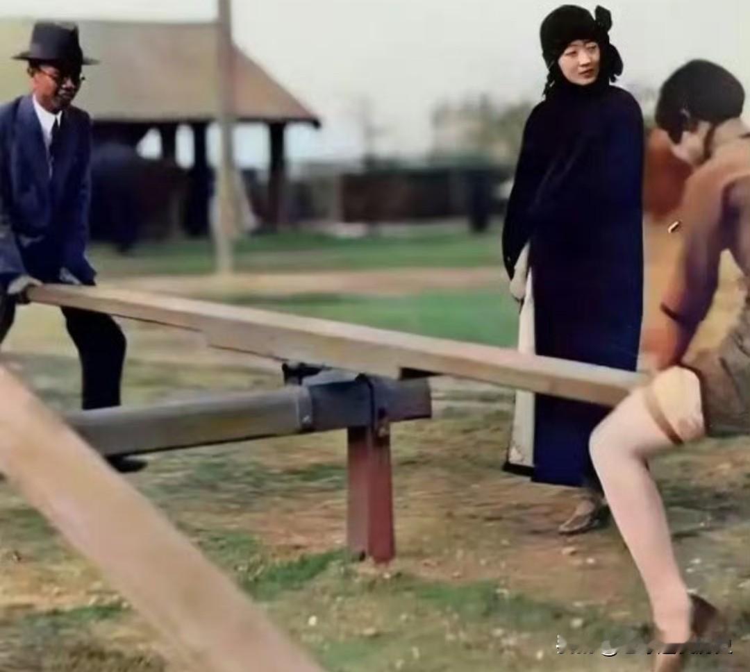 1927年，末代皇帝溥仪与妹妹韫颖在天津玩跷跷板，皇后婉容立于一旁静看，这张珍贵