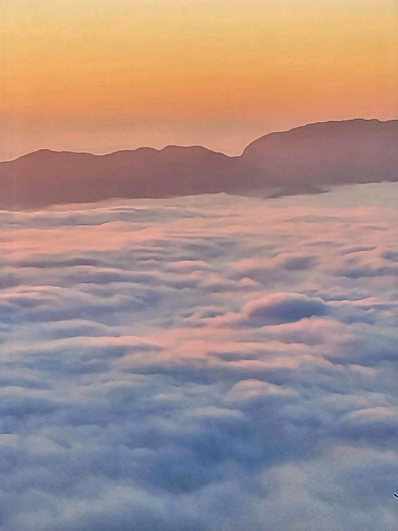 远处的山峦在这光芒的映照下，轮廓变得柔和而神秘，像是一群沉睡苏醒的巨人，正慢慢舒