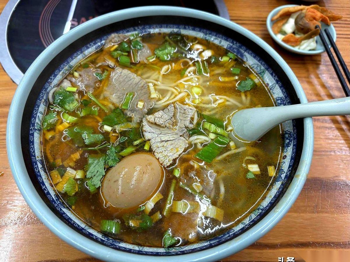 “老板，两碗小份的。”我递过去20块钱。他头都没抬，指了指墙上的价目表：小份1