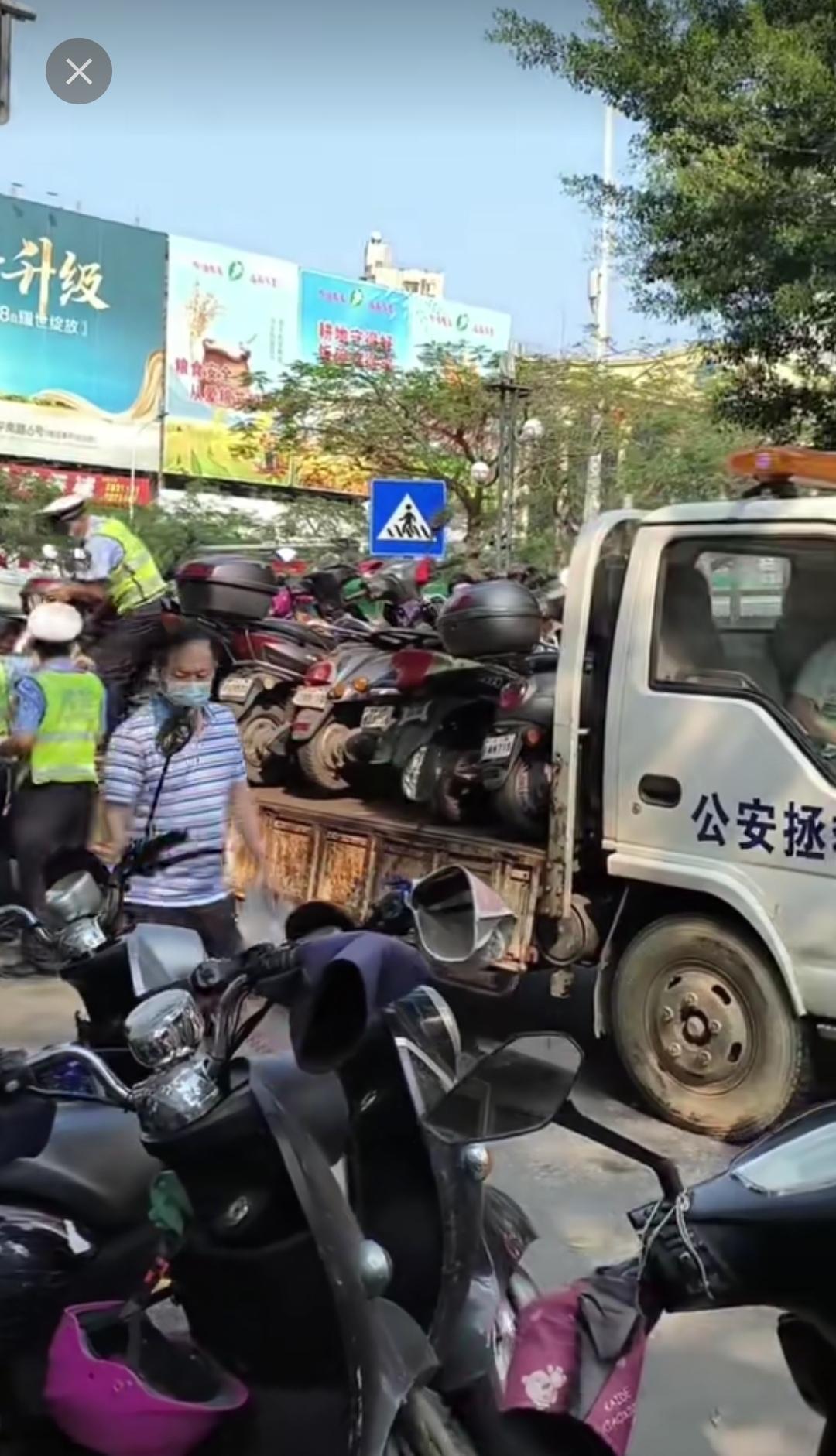 原本写着“公安拯救”的拖车，不只是拖走行驶中出故障的汽车，连路边停放的电动车也在