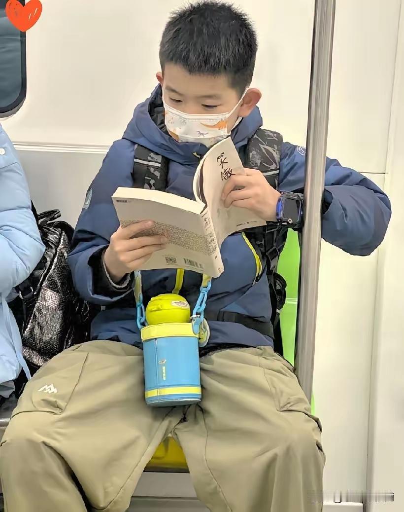 地铁上瞅见个娃，坐那儿抱着本书看得贼入迷，我还心里念叨‘这孩子真省心，坐地铁都不