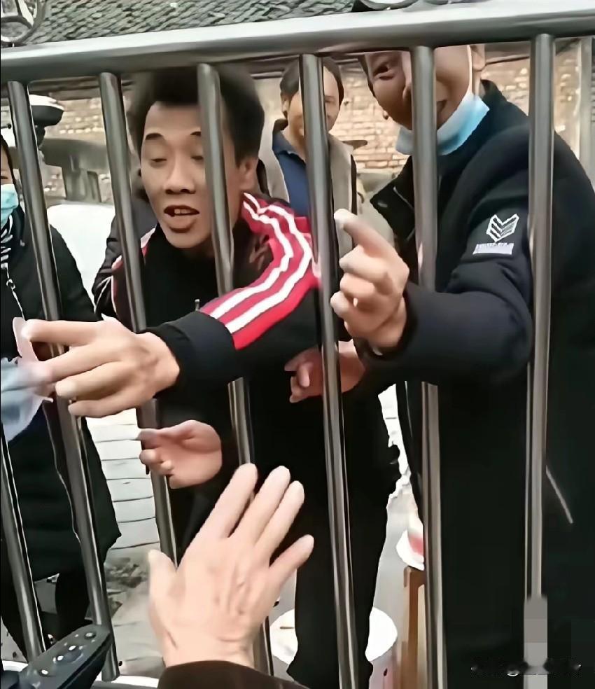 一群子女隔着养老院大门，给养老院的父亲过生日，还伸手抹蛋糕，一阵表演之后走了
