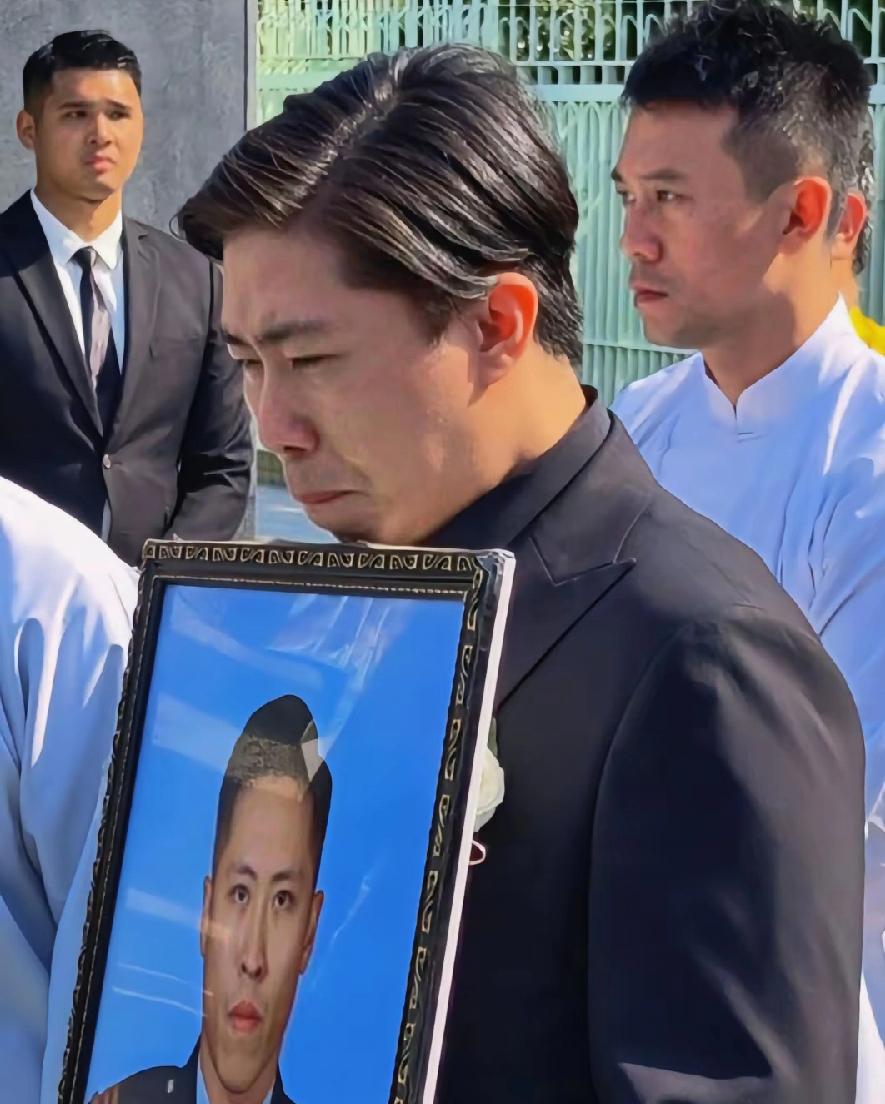 何伟豪葬礼，应该是弟弟手捧遗像，二人长得非常像，何伟豪没有自己的孩子，长辈肯定不