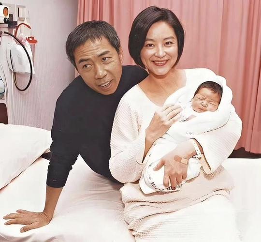 这是1996年，美人林青霞怀抱着刚出生不久的大女儿，老公邢李㷧‌则满脸笑意看着母