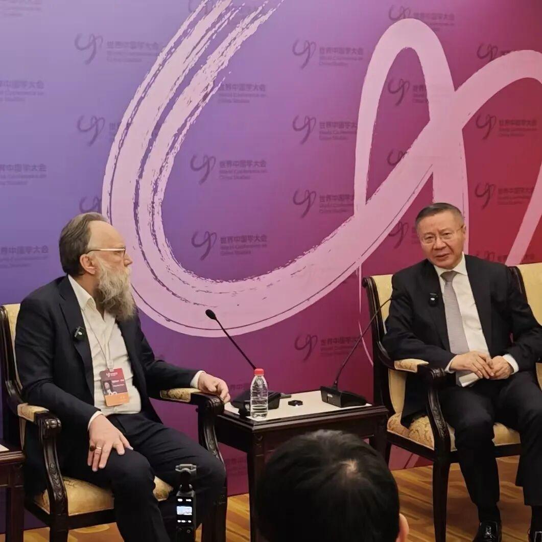 这是张维为教授近期演讲的现场图片。主办方请了两位学者，如图一所示，一位是张维为