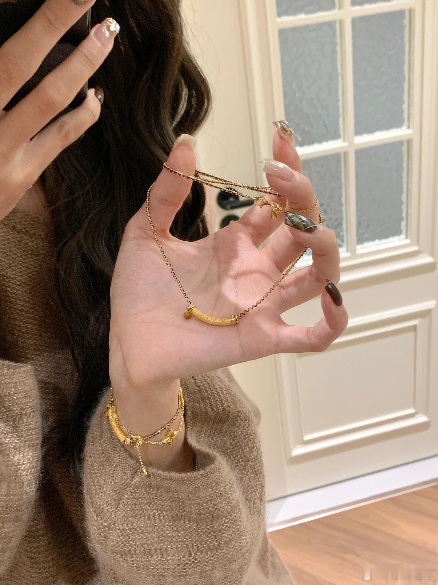 这组叠戴的金色饰品以别致的“香蕉”造型为核心，洋溢玩趣与时尚感。主体为两条叠戴的