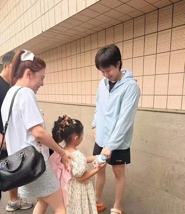 王楚钦与师母合影背手站得笔直，牵起教练女儿却满脸温柔，这教养细节谁看了不点赞？