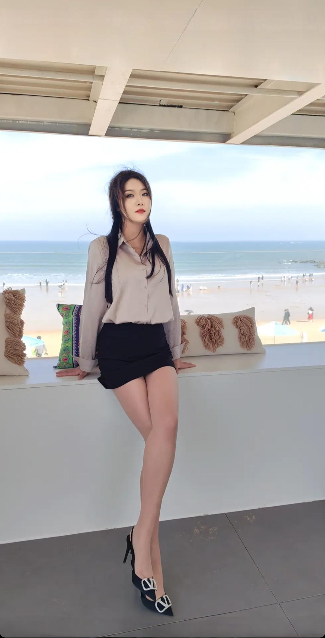 海边风景美，人靠窗边看海。