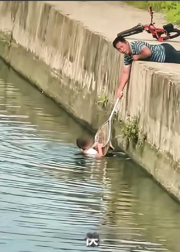 广东东莞发生暖心一幕，一名男孩意外失足落水，慌乱之中紧紧抓着岸边挣扎求救。危急时