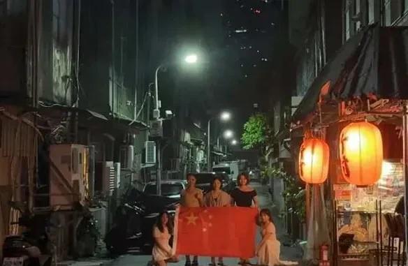 有几位大陆籍在澳门读书的学生赶赴台湾省看演唱会时，在台湾省街头手拿五星红旗拍照。