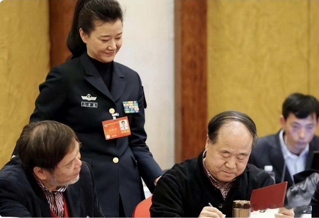 这张老照片看着特别有意思，两会休息的空档，宋祖英拿着画册来找莫言签名。明明是很有