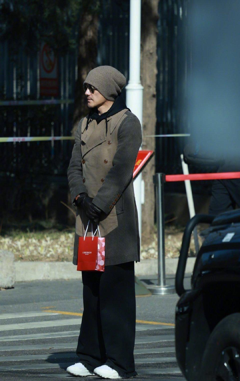 胡兵把秀场搬到央视门口别人是参加春晚彩排，胡兵是来走秀的吧！灰色针织冷帽配墨镜