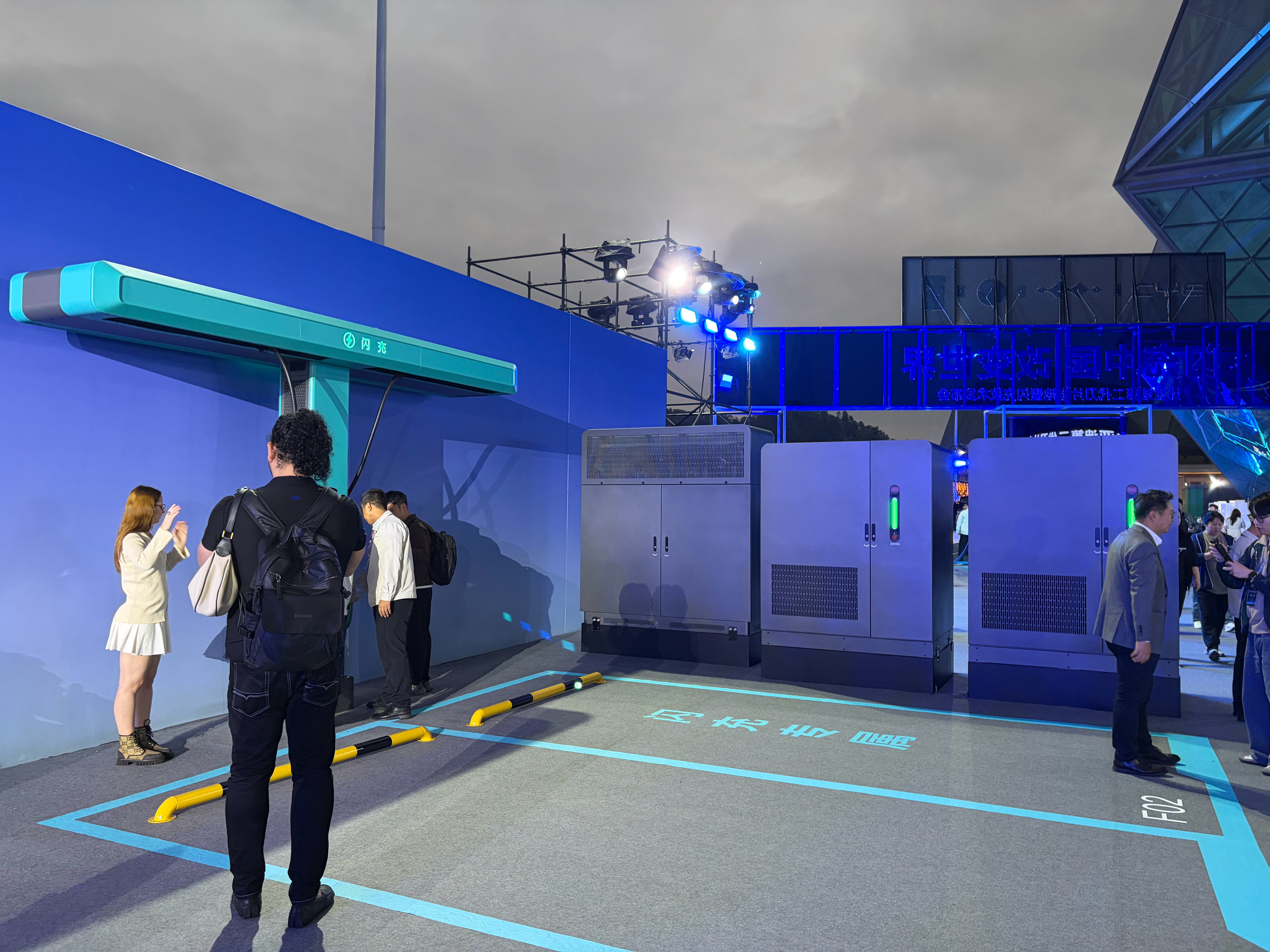 现场已经可以看到比亚迪的闪充，还是一桩双枪的布置，设计还蛮巧妙的，上面做了个滑轨