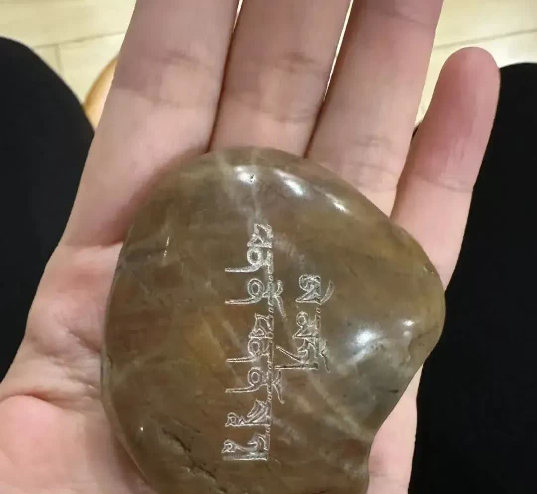 河北，一名女子在河岸边洗衣服时，意外捡到了一块掌心大小的石头，女子感觉它挺好看的