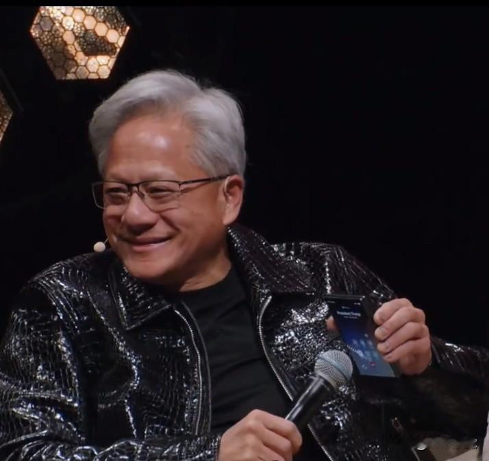 英伟达老板黄仁勋手里拿着折叠屏手机，会议现场接到重要人物的电话，开了免提，屏幕上