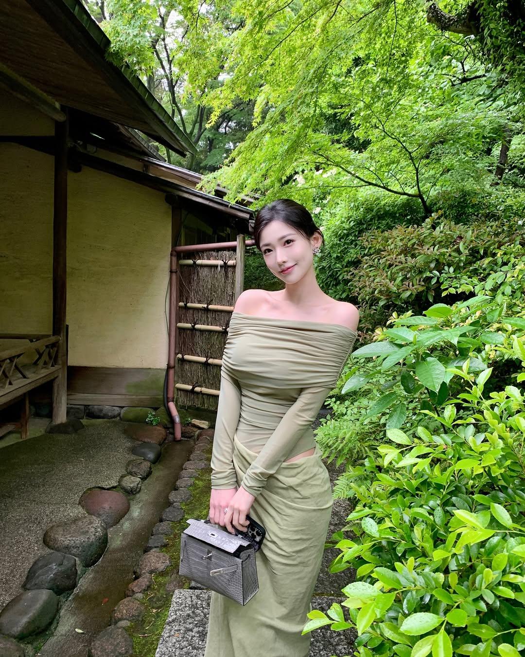 模特小姐姐一袭浅绿色露肩长裙，优雅与时尚并存。露肩设计展露迷人肩颈线，修身剪裁完