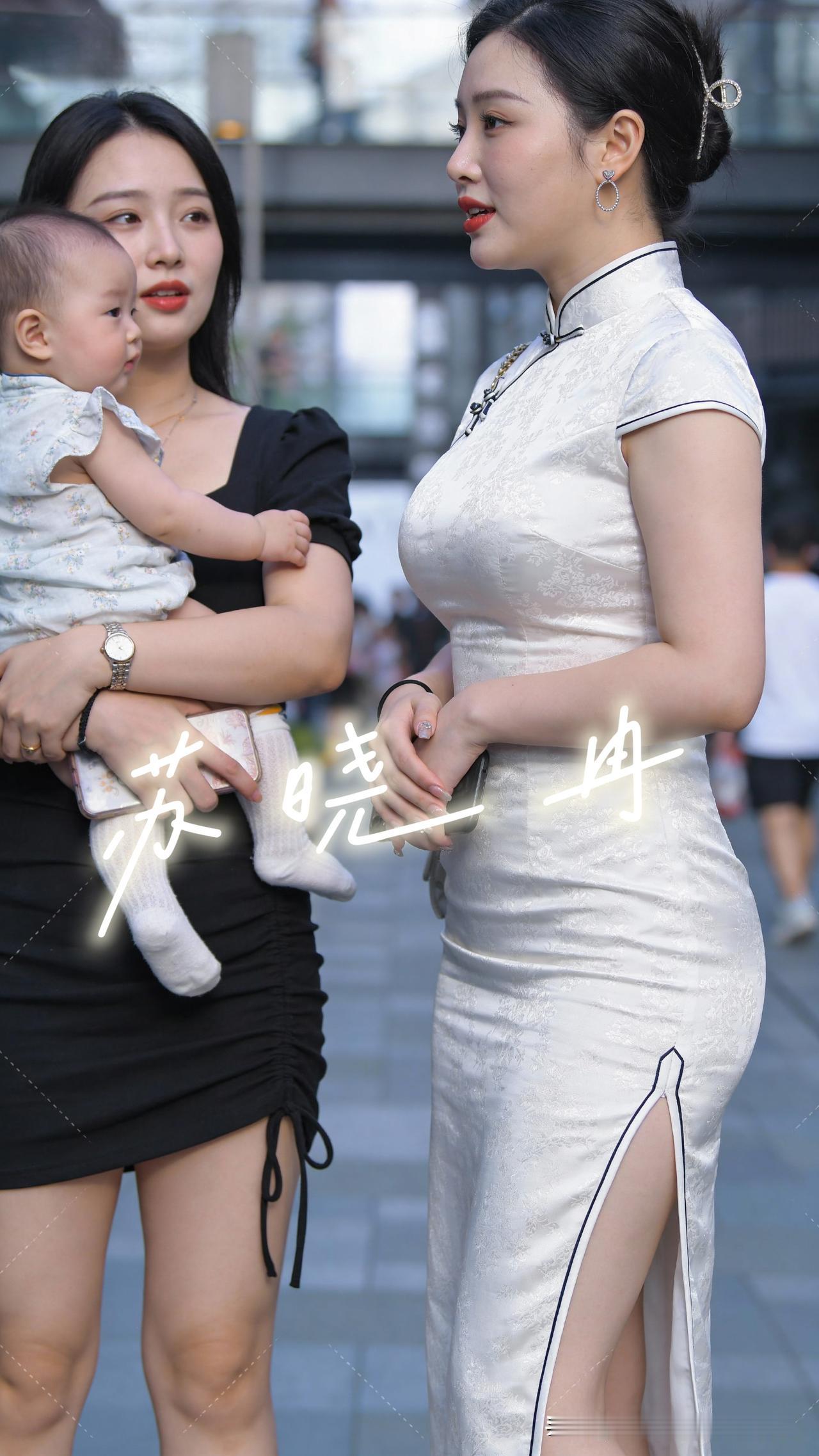 城市的街头，旗袍的盘扣系着东方的韵致，怀里的小生命攥着世间最软的温柔。水墨