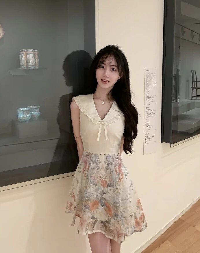 在艺术馆里，穿着花裙子的女孩，微笑面对镜头。