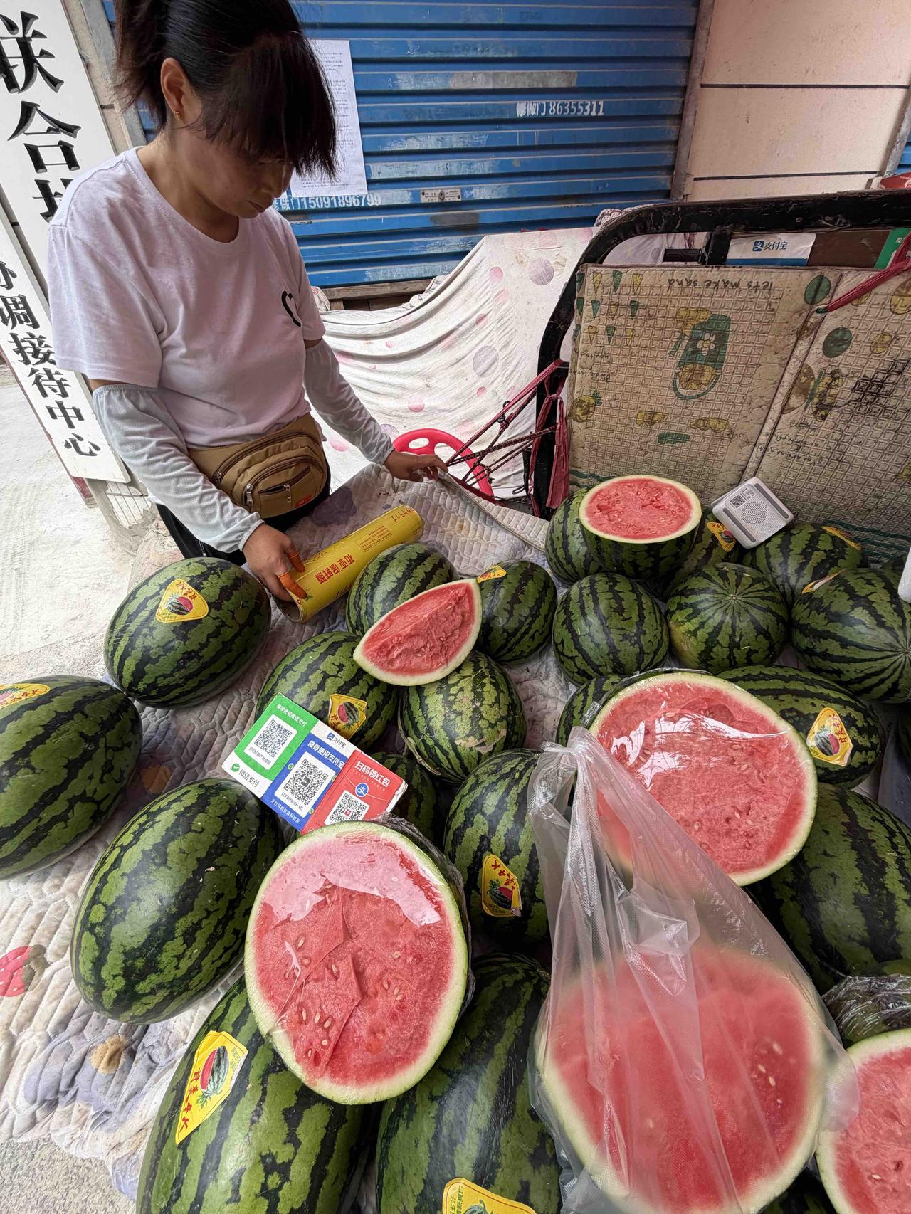 今天上午，我去西安劳武巷买水蜜桃，看到一家摊上，西瓜一块钱一斤，女老板正在切一个