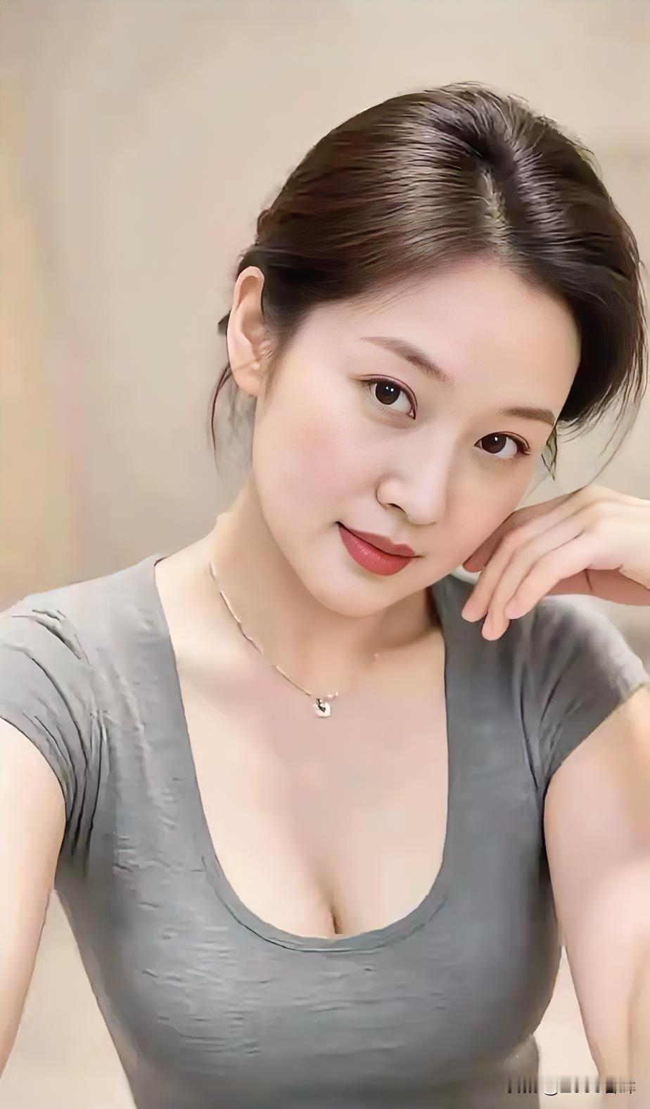 灰衫勾勒从容，素颈承托温柔。发梢轻挽时光，笑意藏于眼眸。不逐喧嚣