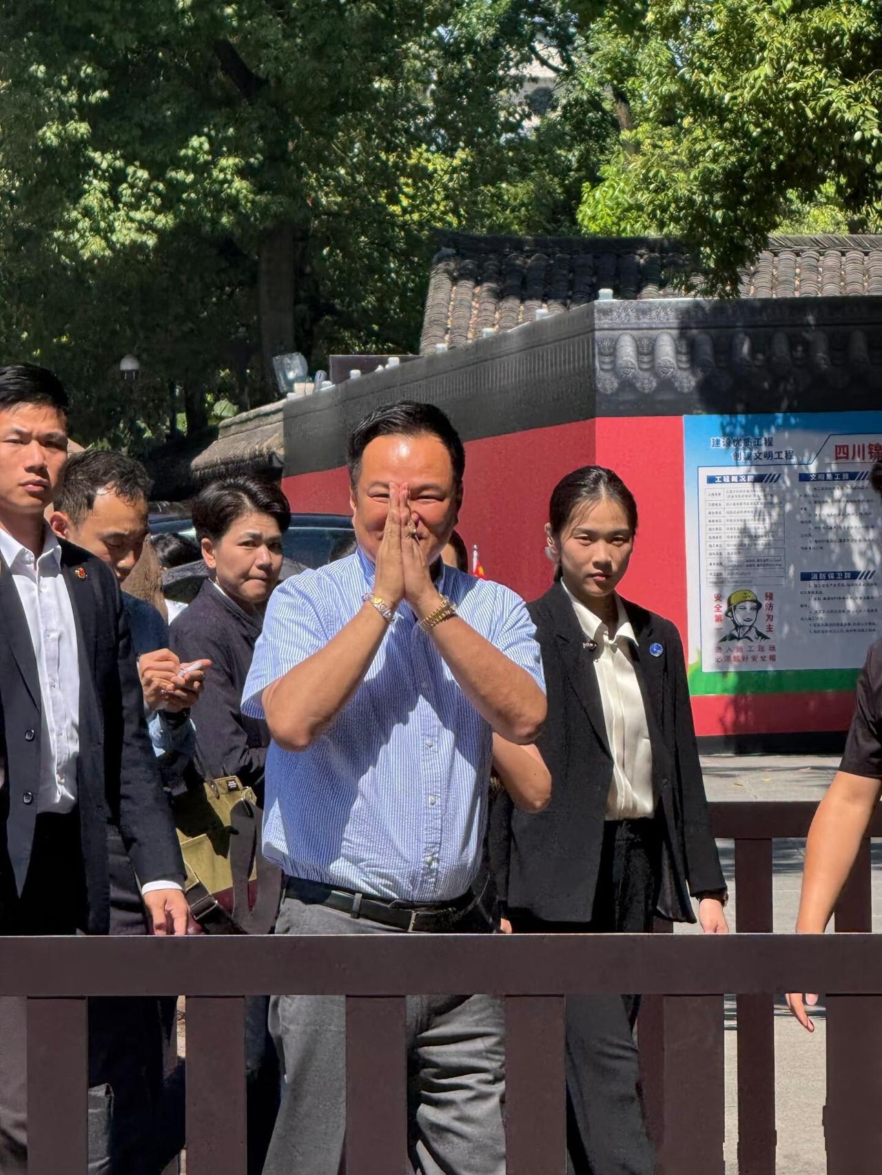 7月19日泰国总理阿努廷带着80后妻子打卡武侯祠，穿蓝白细条纹衬衫与灰裤，太减龄