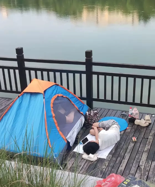 广东，有一名女子早上到河边跑步，远远看到河边的木板走道上，有人支起来一顶帐篷，女