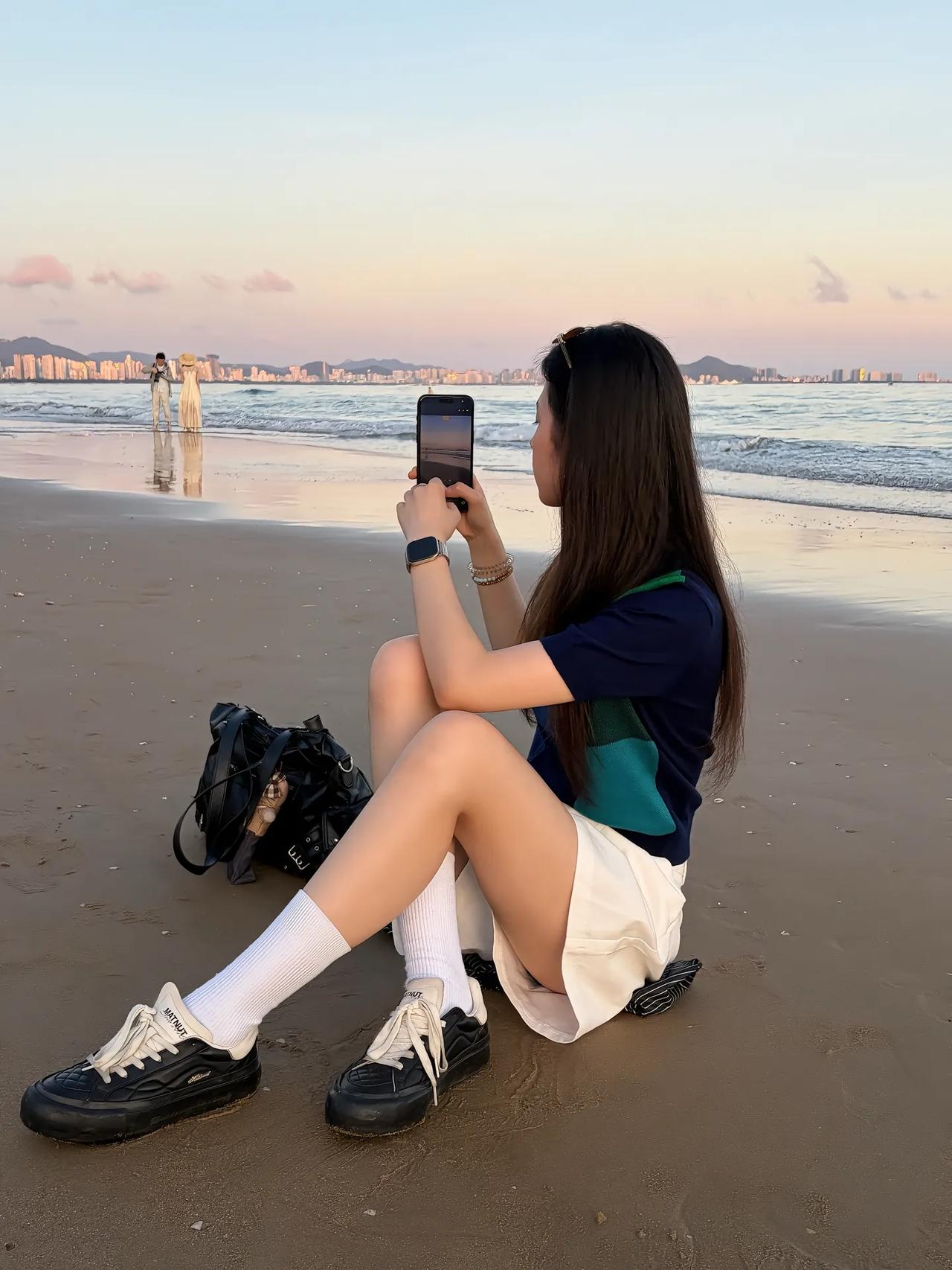 海浪，沙滩，晚霞还有美女。海浪一波波地打在沙滩上，发出有节奏的声响。天空被晚霞染