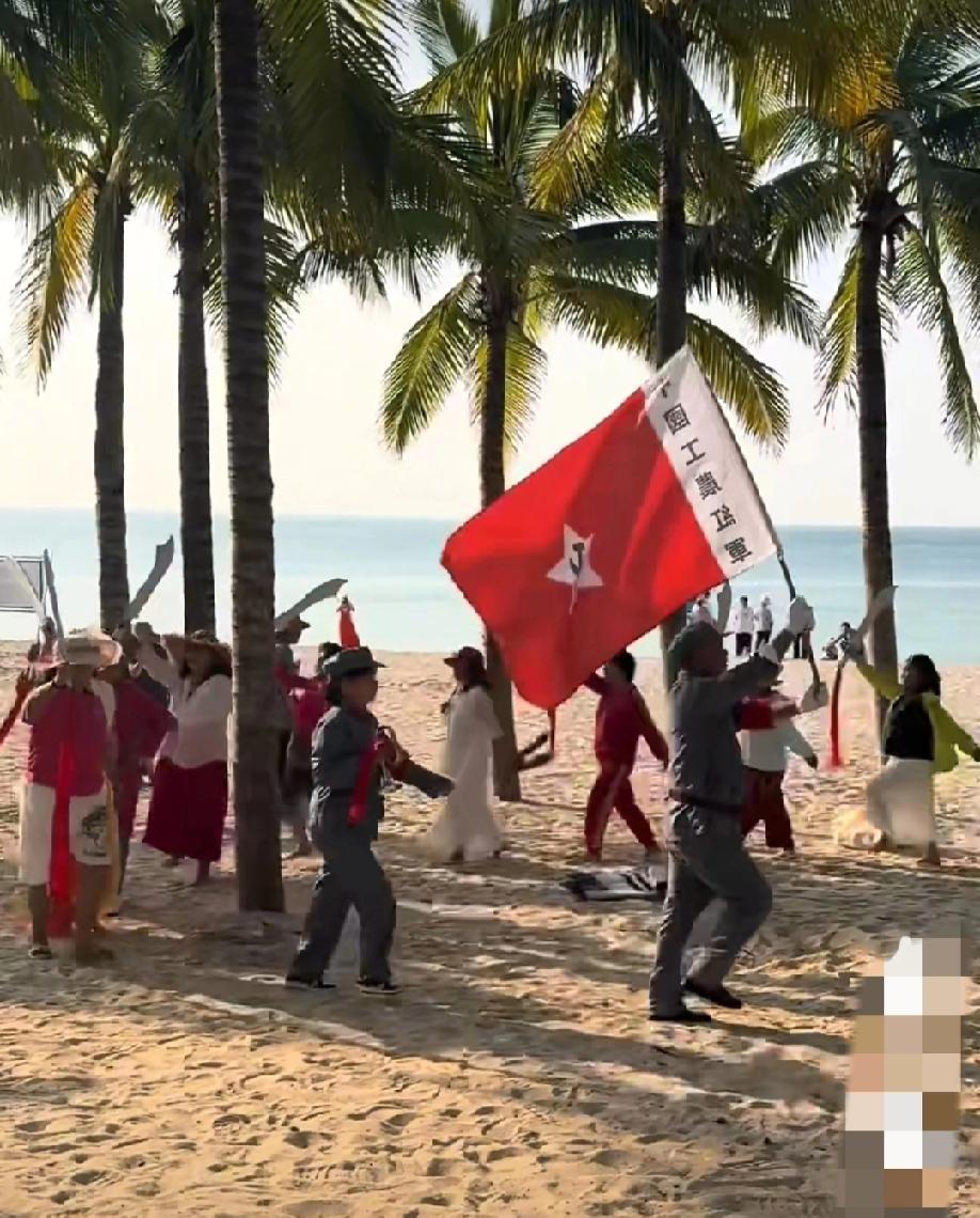 海南三亚，沙滩上的一幕:大爷手举“中国gnhj”的红旗，嘴里喊着“1234”的口