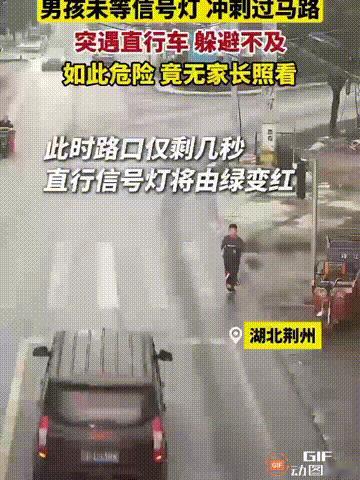 湖北荆州一处街头，一个男孩急着去往马路对面，他虽然走到斑马线上，但却没有注意交通