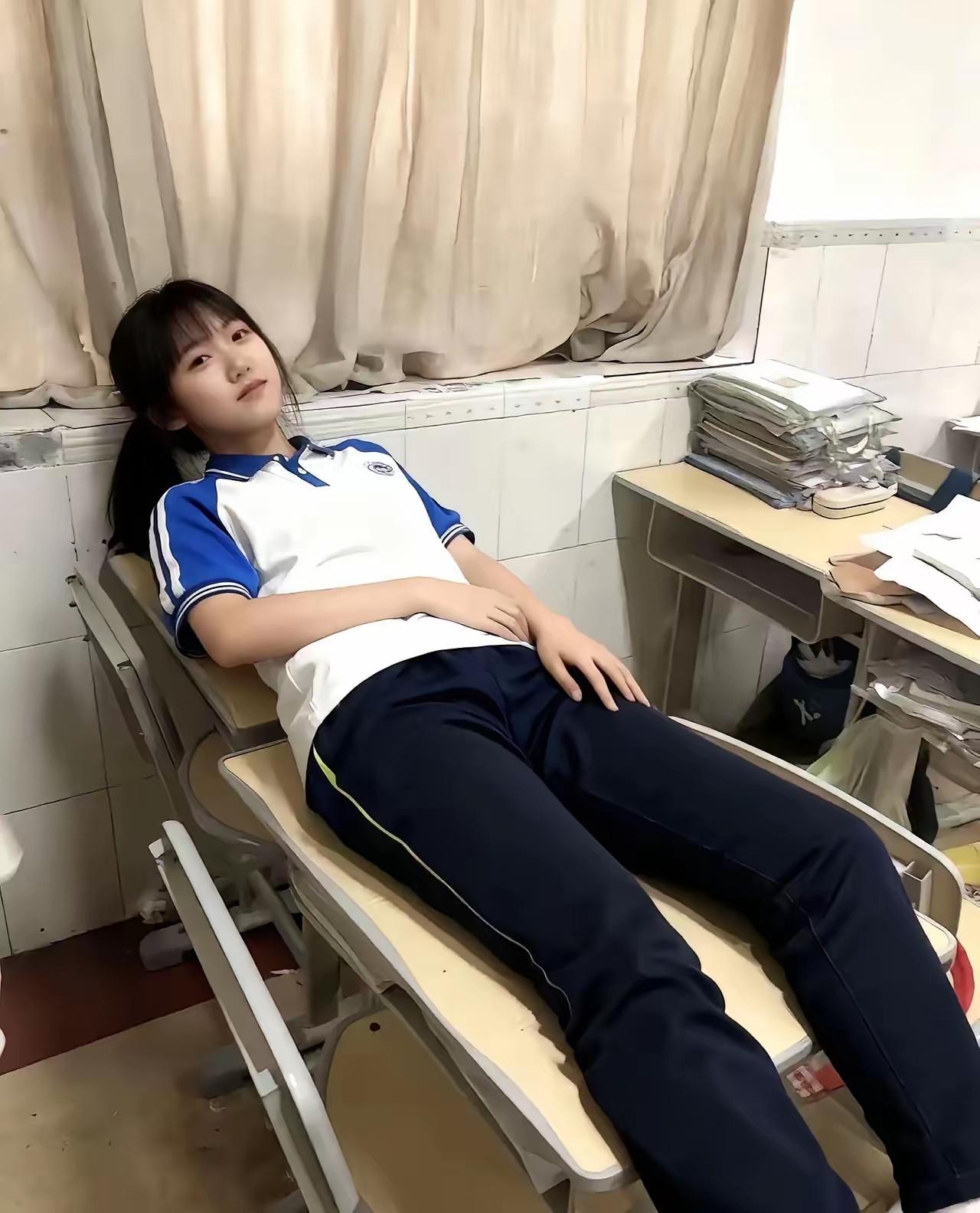 她正在教室里躺着休息。躺床上女孩教室美女课堂上睡着美少女书桌我也在向她学