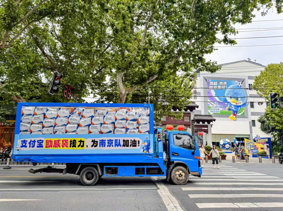 苏超助威袋坐着卡车来南京了满载苏超助威袋的透明卡车现身南京街头，熙南里、万达等多