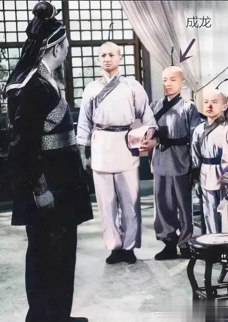 成龙旁边的两位师兄弟，虽然没有明确指出他们是谁，但从照片中可以看出他们与成龙有着
