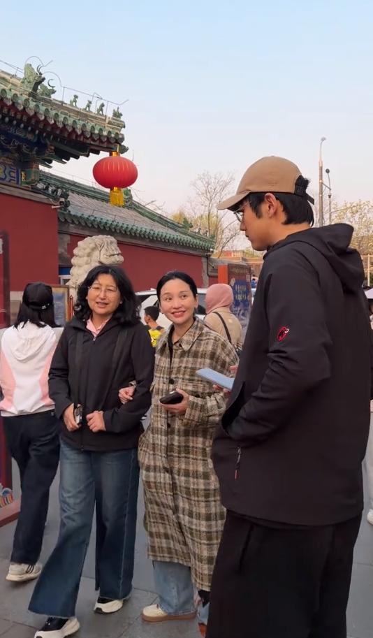 金莎和孙丞潇带着孙妈妈北京度假，穿着格纹长款大衣的金莎主动挽着婆婆手臂，笑容甜美