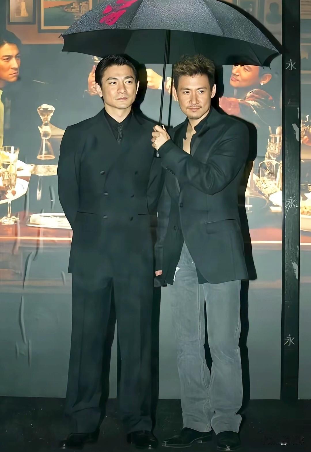 双王同框，气场全开。张学友执伞相护，刘德华沉静伫立，伞下藏着岁月沉淀的默契。无需