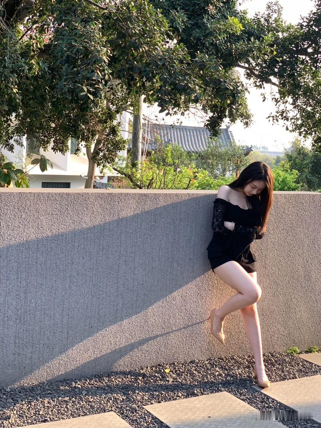 优雅黑裙，倚墙轻靠，静享午后时光