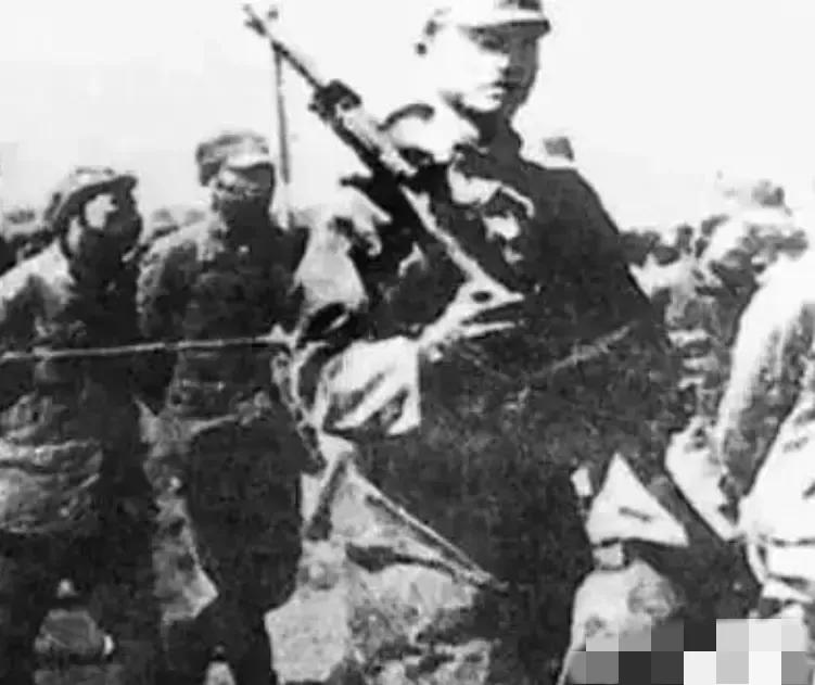 1942年，在日军海州战俘营里，5个看守日军正在喝酒吃肉，角落里一名躺在地上的八