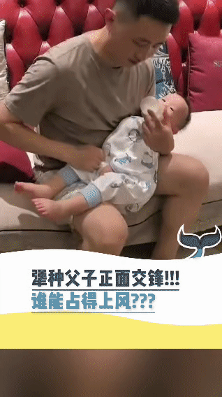 被这对父子给逗乐啦！奶爸坐在沙发上，专心致志地给宝宝喂奶。小家伙倒好，喝着喝着