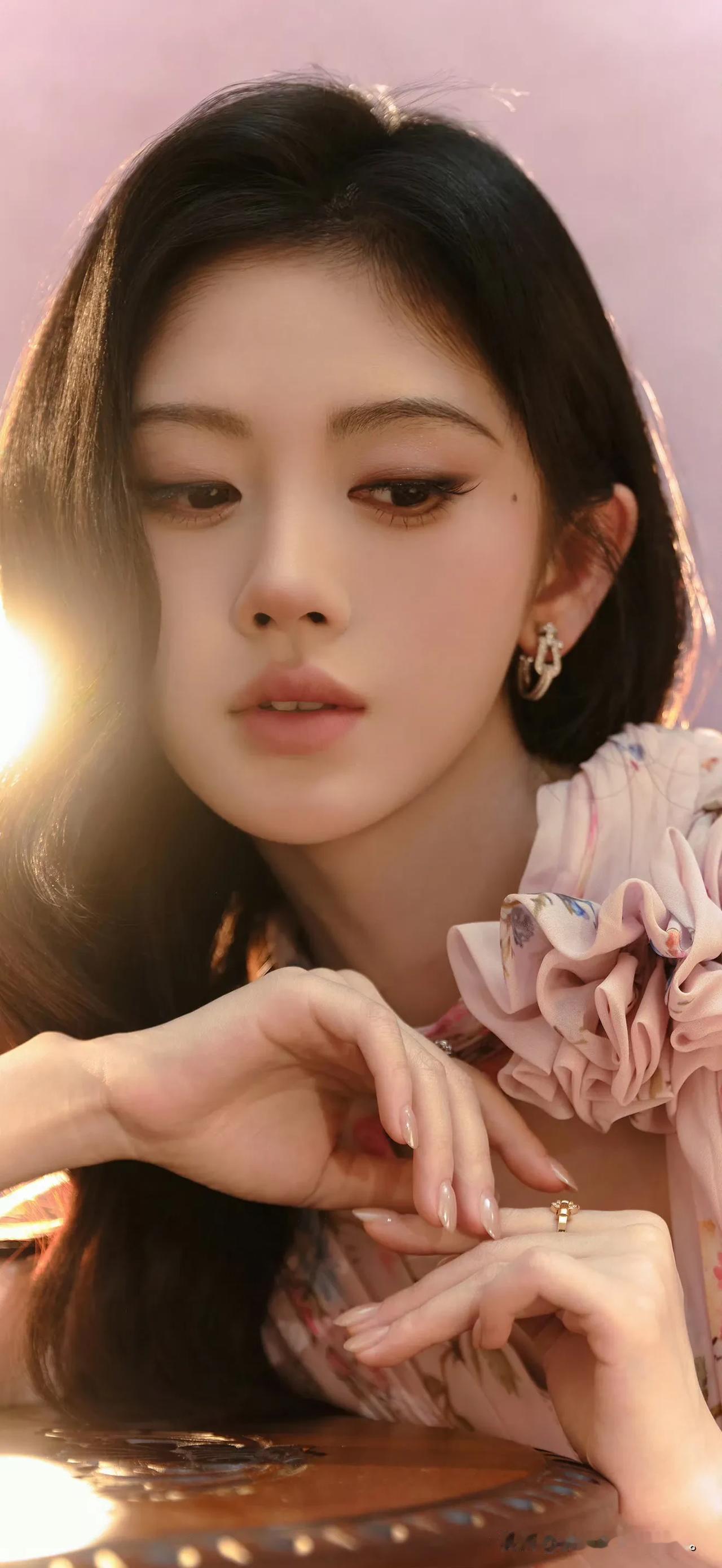 鞠婧祎在暖阳光影里，眼神温柔似水，粉色花朵与精致妆容交织出春日浪漫氛围。鞠婧祎风