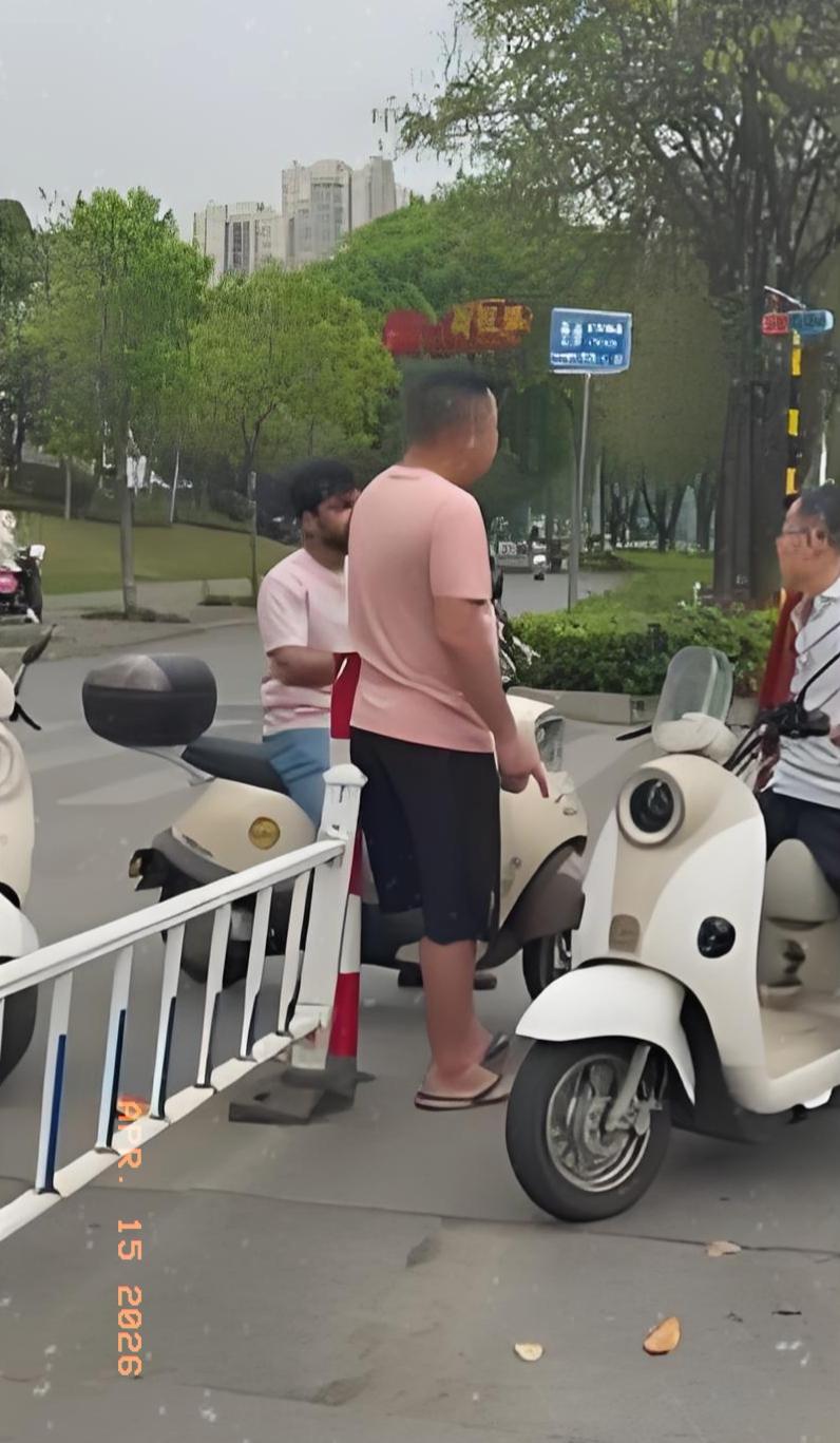 最近在广西柳州，一位穿粉色衣服的大哥骑电动车在路上，被一名同样骑电动车的外国人恶