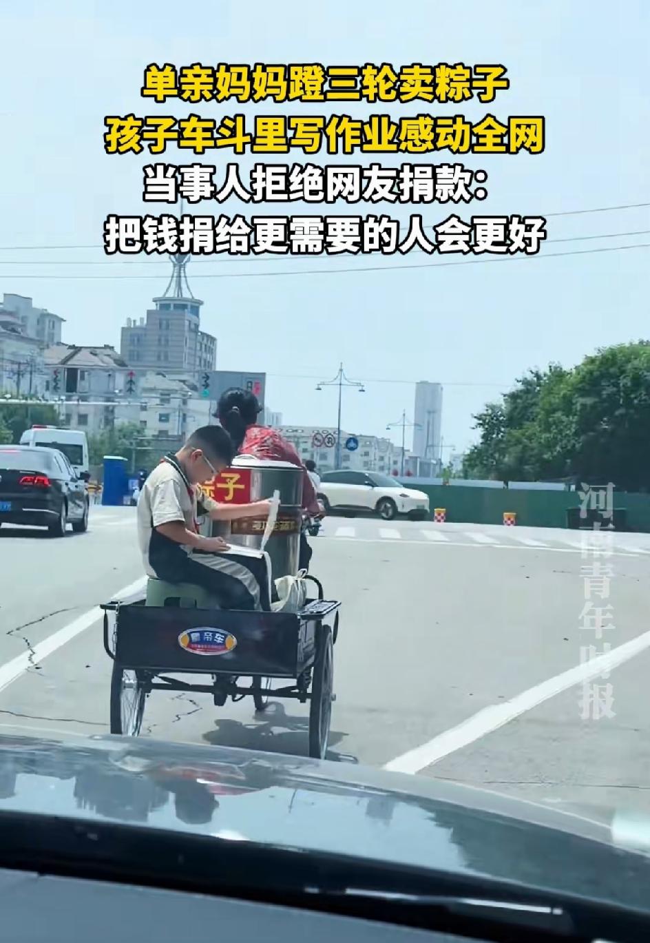 为母则刚，单亲妈妈登三轮车卖粽子。儿子坐在车后面写作业。这一幕感动了路人，拍下了