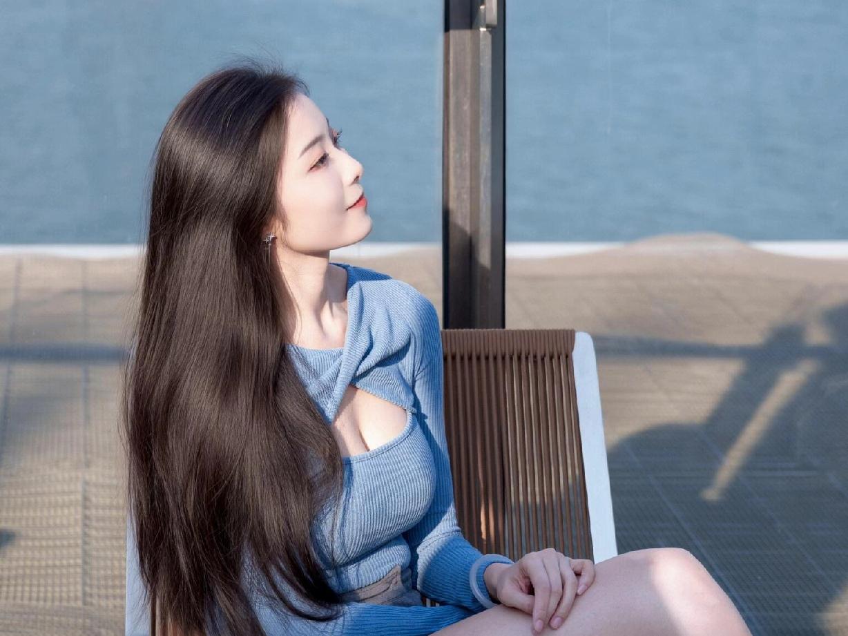 栈道上的春日序章她把午后的时光叠进风衣口袋蓝色针织衫漫过肩头，像一截安静