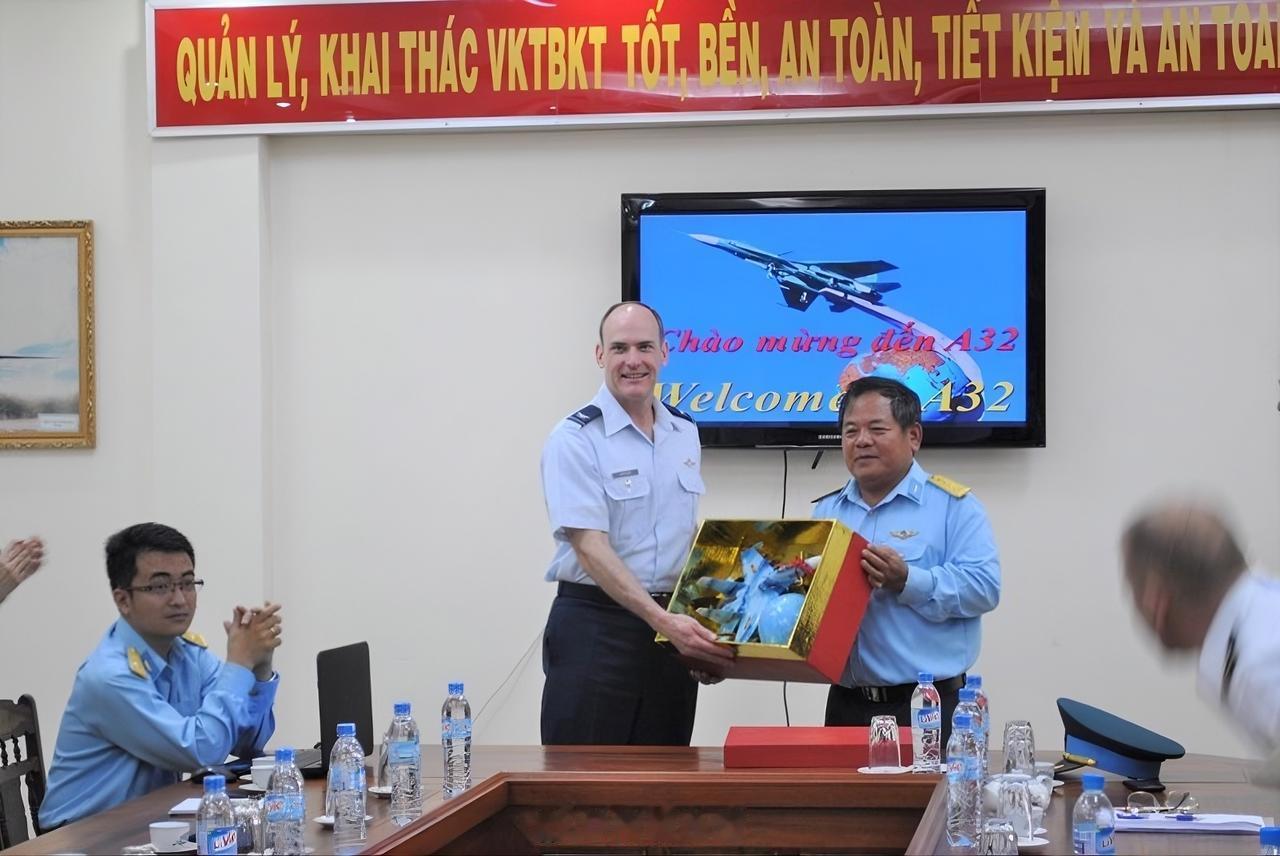 越南防空空军A32工厂的员工正在带领美国空军学院的代表团参观工厂。背景中是一架苏