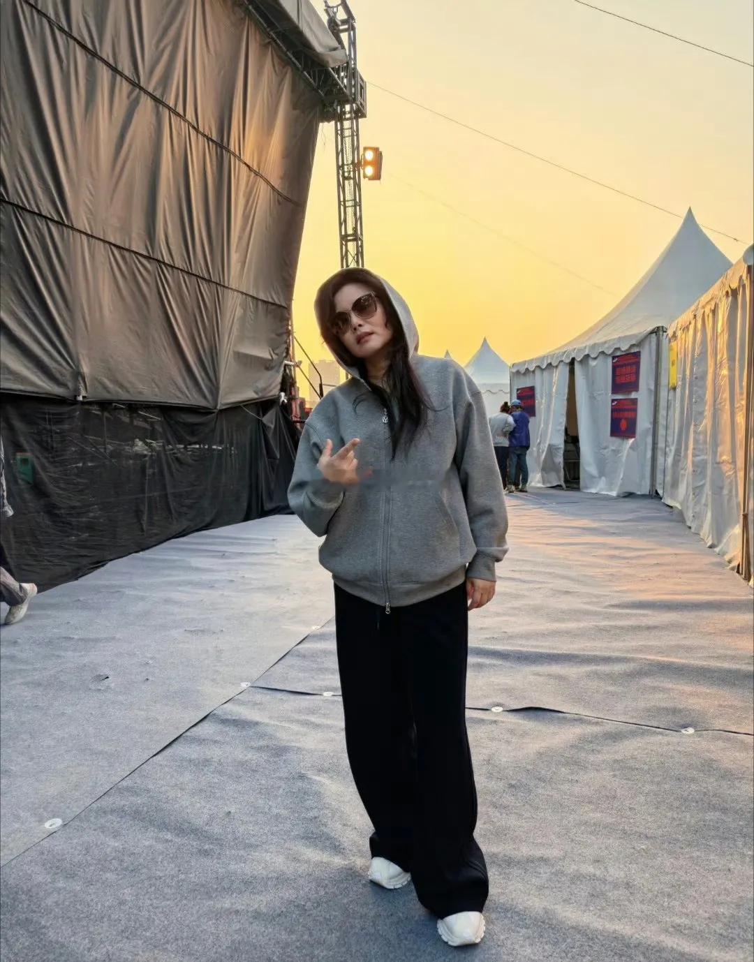 50岁的女人穿黑白灰，是真的显气质！你看龚琳娜这身——灰色连帽卫衣配黑色阔腿裤，