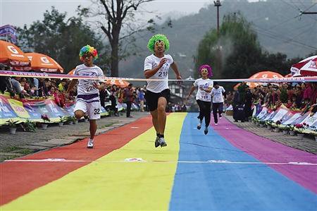 参加高跟鞋彩色跑的选手奋力冲向终点.
