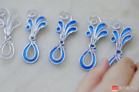 宁静埋头做粤剧头饰已有25年,她双手在娴熟地掐铁丝做配饰造型.